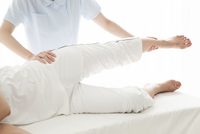 患者の足の状態を確認するスタッフ