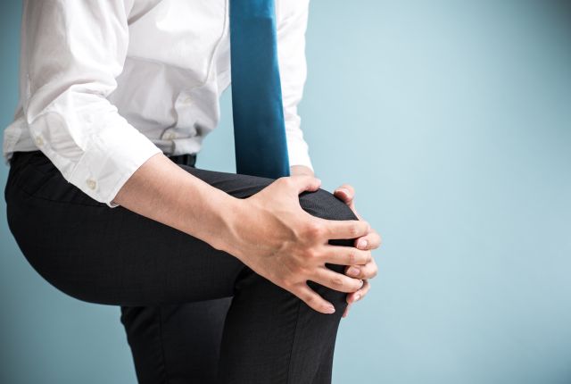 膝をかかえるビジネスマン