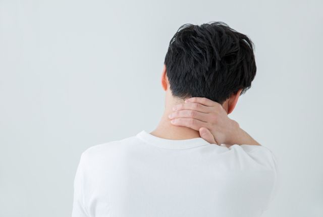 首の痛みを感じる男性